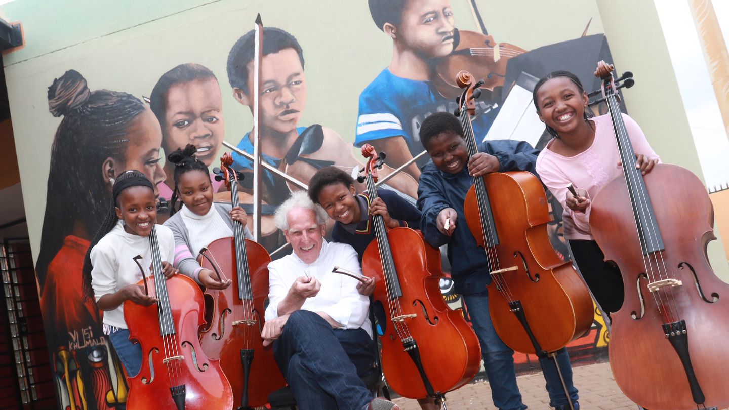 Benjamin Zander with young cellists in Soweto, South Africa, in 2019.