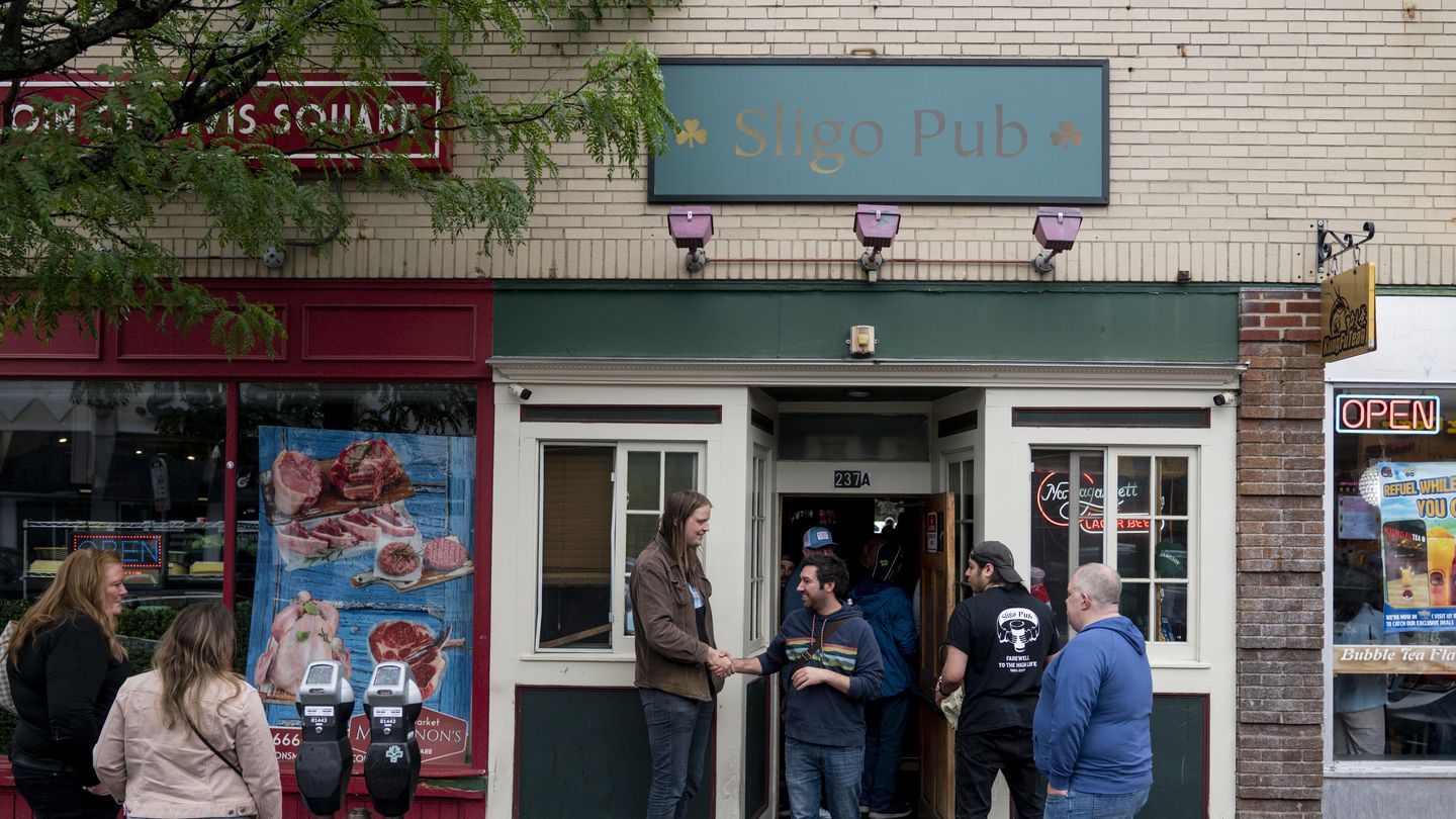 Patrons conversed outside of Sligo Pub, a dive bar in Davis Square, which closed after 75 years.