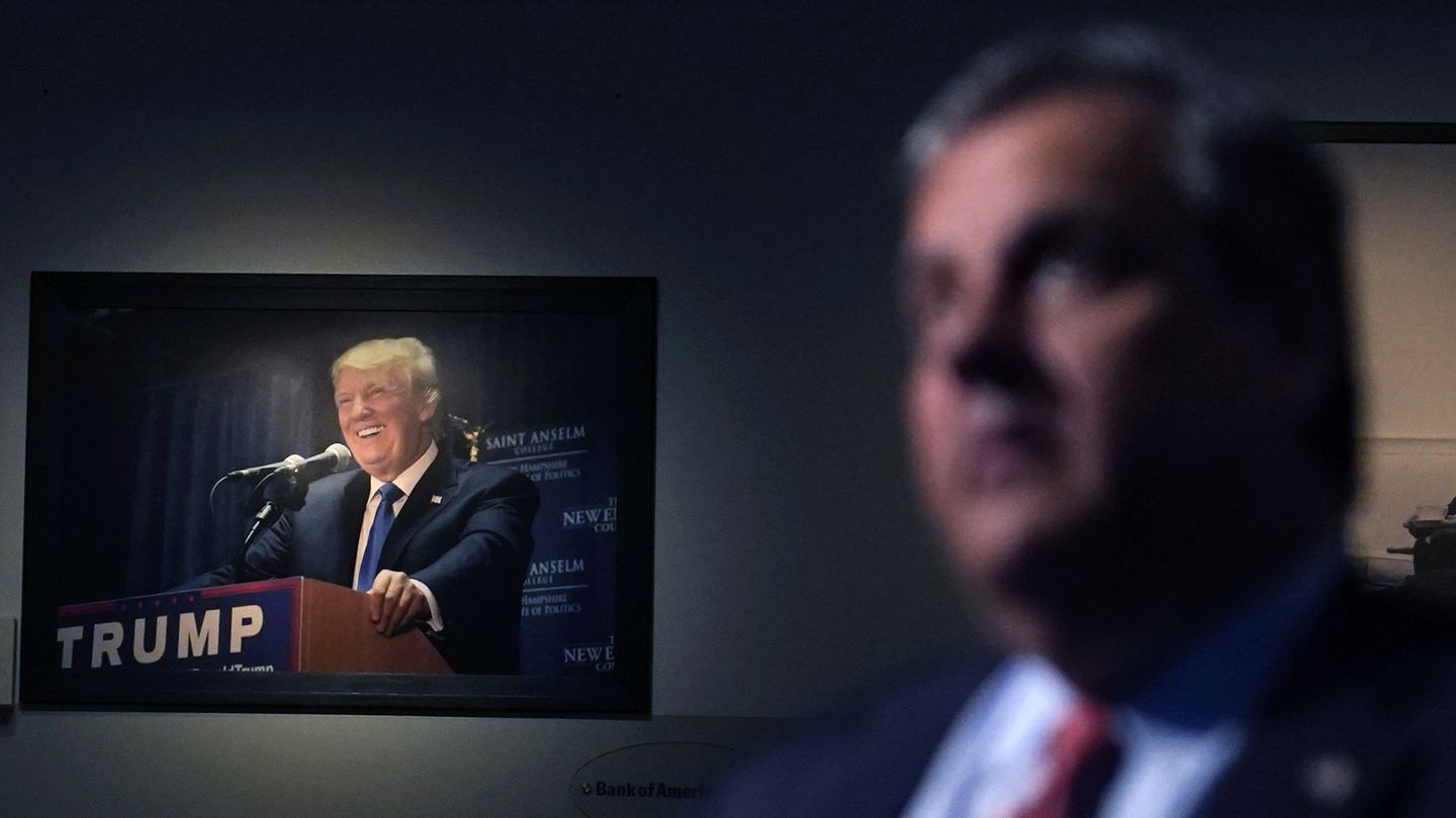 A photograph of former President Donald Trump hangs on the wall as Republican presidential candidate, former New Jersey Gov. Chris Christie listens to a question during a gathering, Tuesday, June 6, 2023, in Manchester, N.H. Christie filed paperwork Tuesday formally launching his bid for the Republican nomination for president after casting himself as the only candidate willing to directly take on Trump.