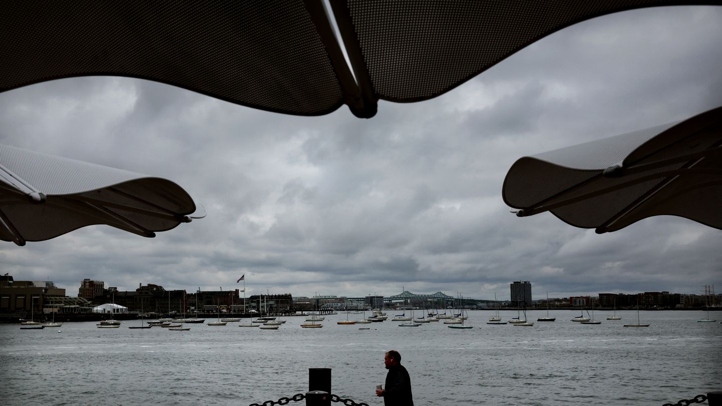 A pedestrian is framed by canopies along the Boston Harborwalk at Fan Pier Park in the Seaport District of Boston, MA on April 26, 2023.
