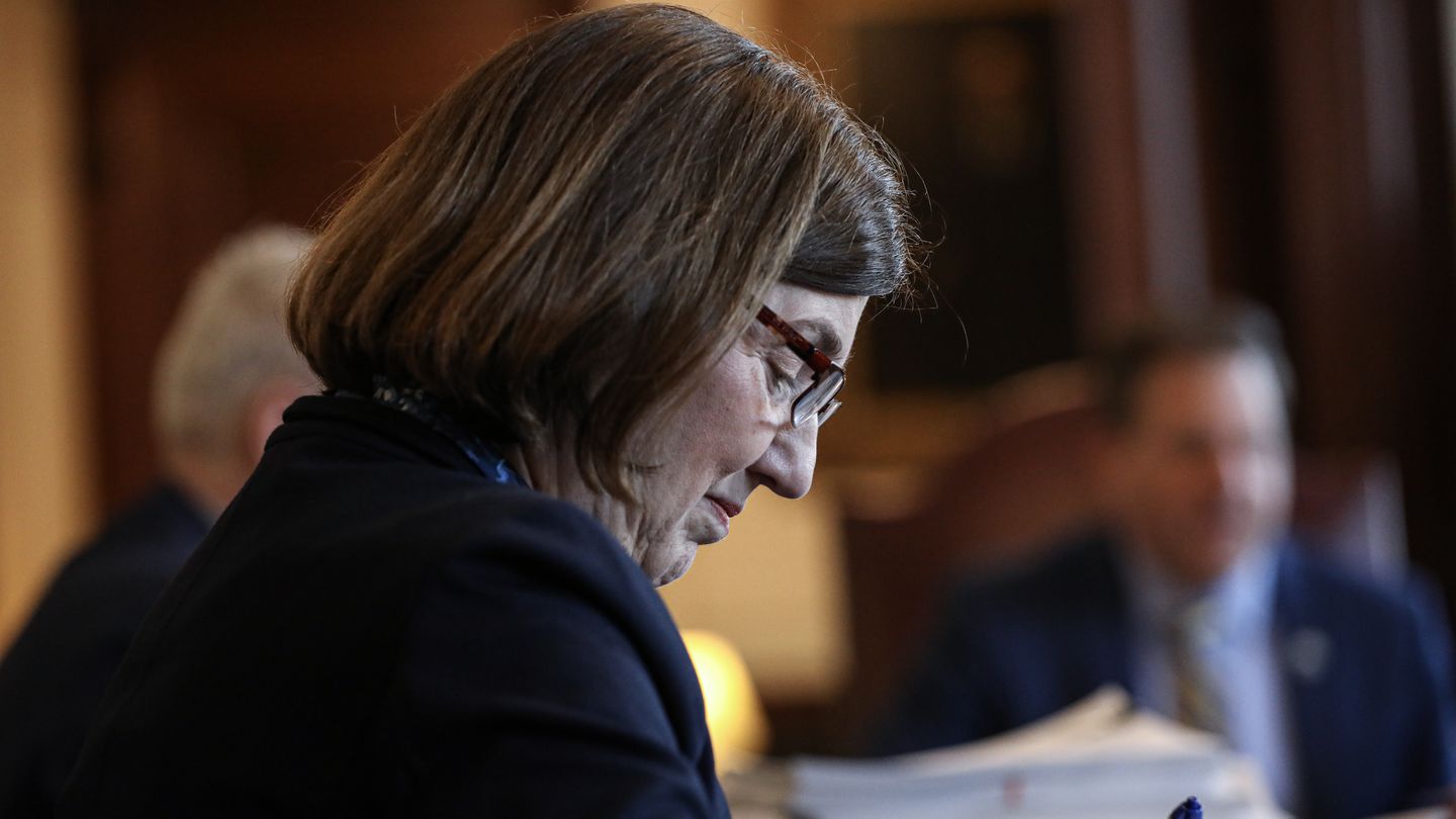 Executive Counselor Cinde Warmington takes notes, Governor Chris Sununu in background, during an Executive Council meeting at the State House, March 22, 2023.