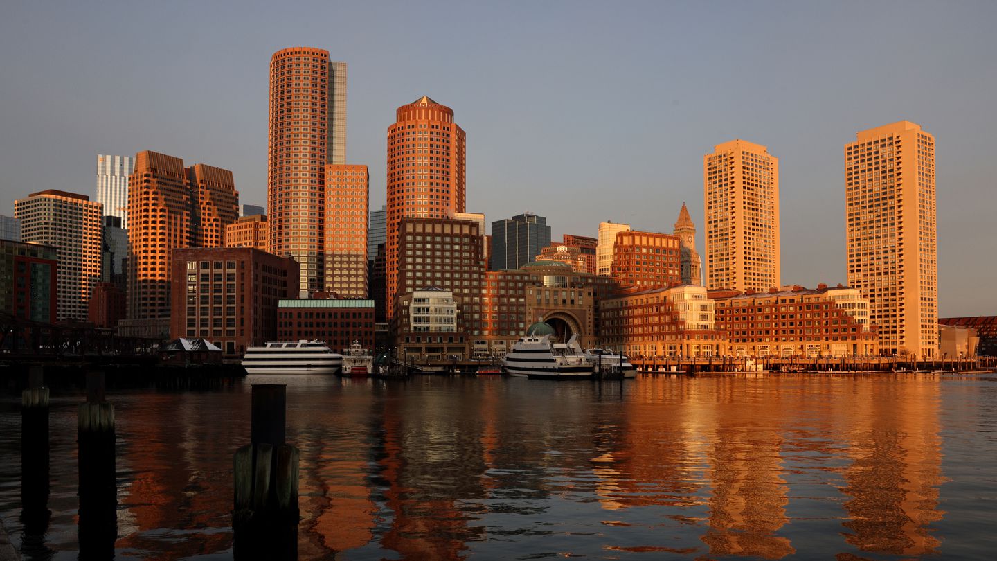 The Boston skyline at sunrise, viewed from Fan Pier Park in the Seaport District of Boston.