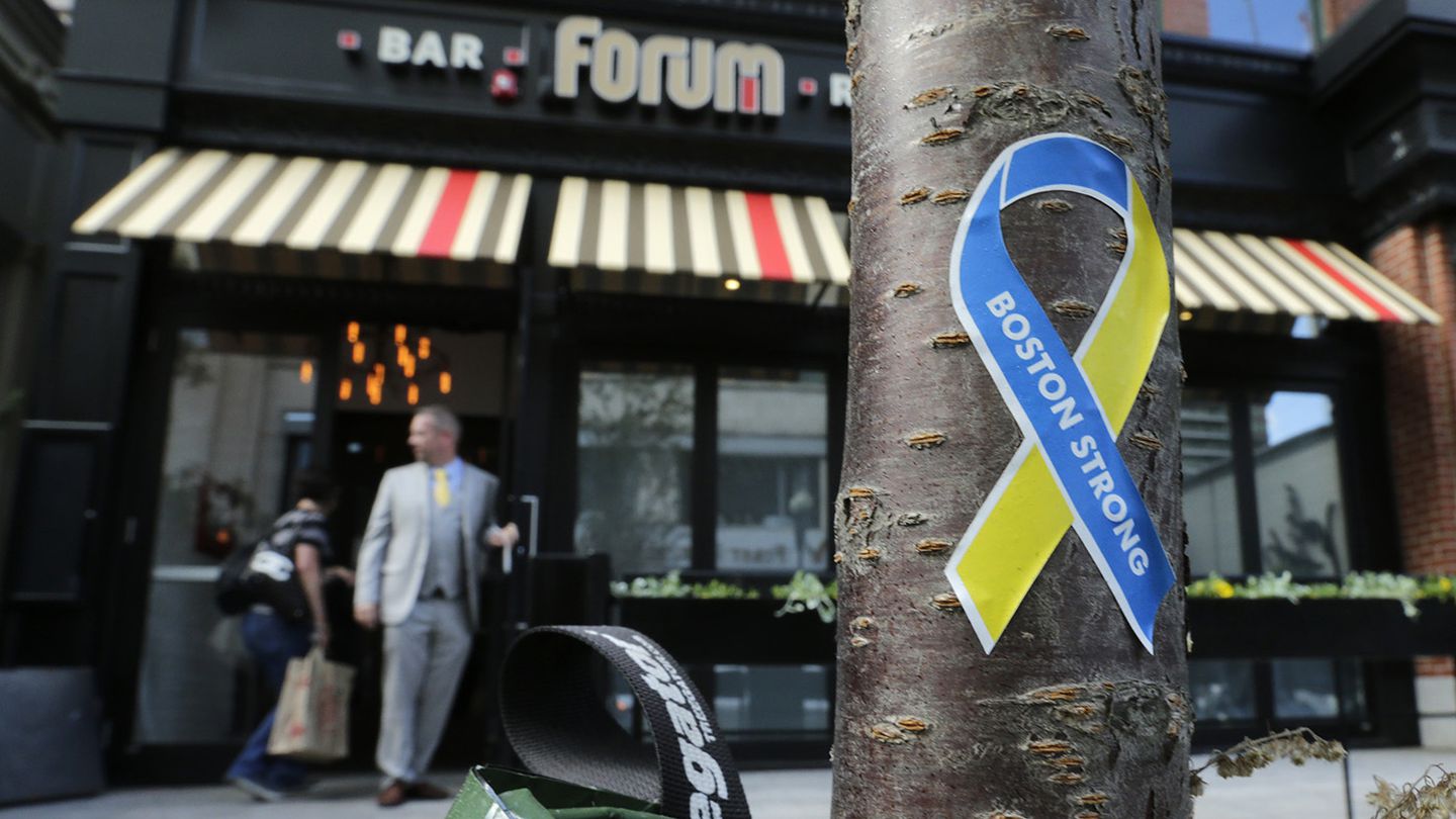 A "Boston Strong" sticker stuck to the trunk of a tree as a manager opened the door to the Forum restaurant and bar near the finish line of the Boston Marathon, in Boston, Thursday, Aug. 15, 2013.  The restaurant was damaged after one of the bombs exploded in front of the building.