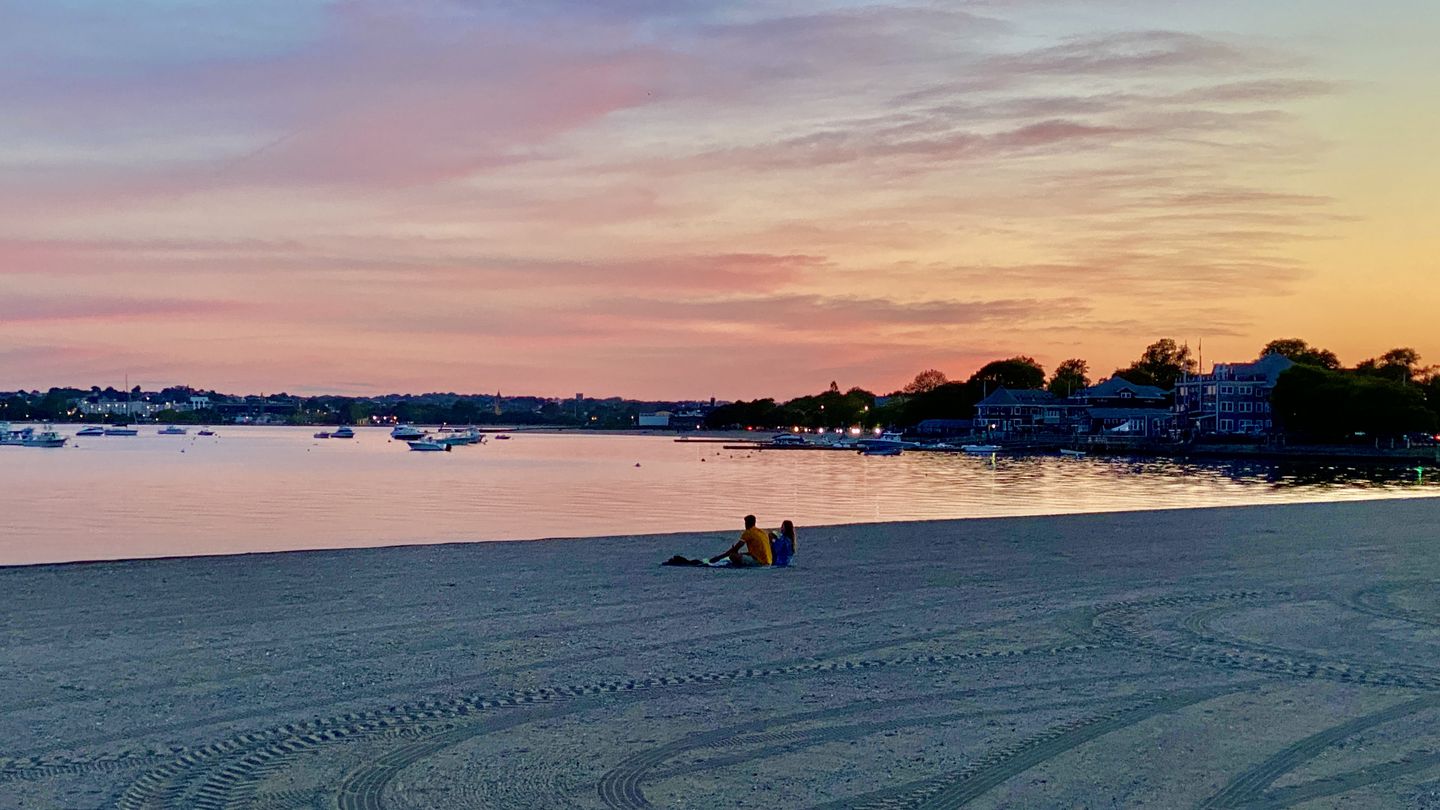A couple enjoys sunset at Pleasure Bay Beach in South Boston.