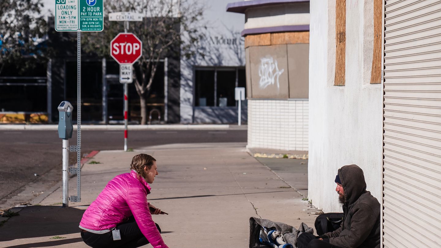 An outreach worker asks a man experiencing homelessness to answer questions during a Point-in-Time count on Jan. 24, 2023.