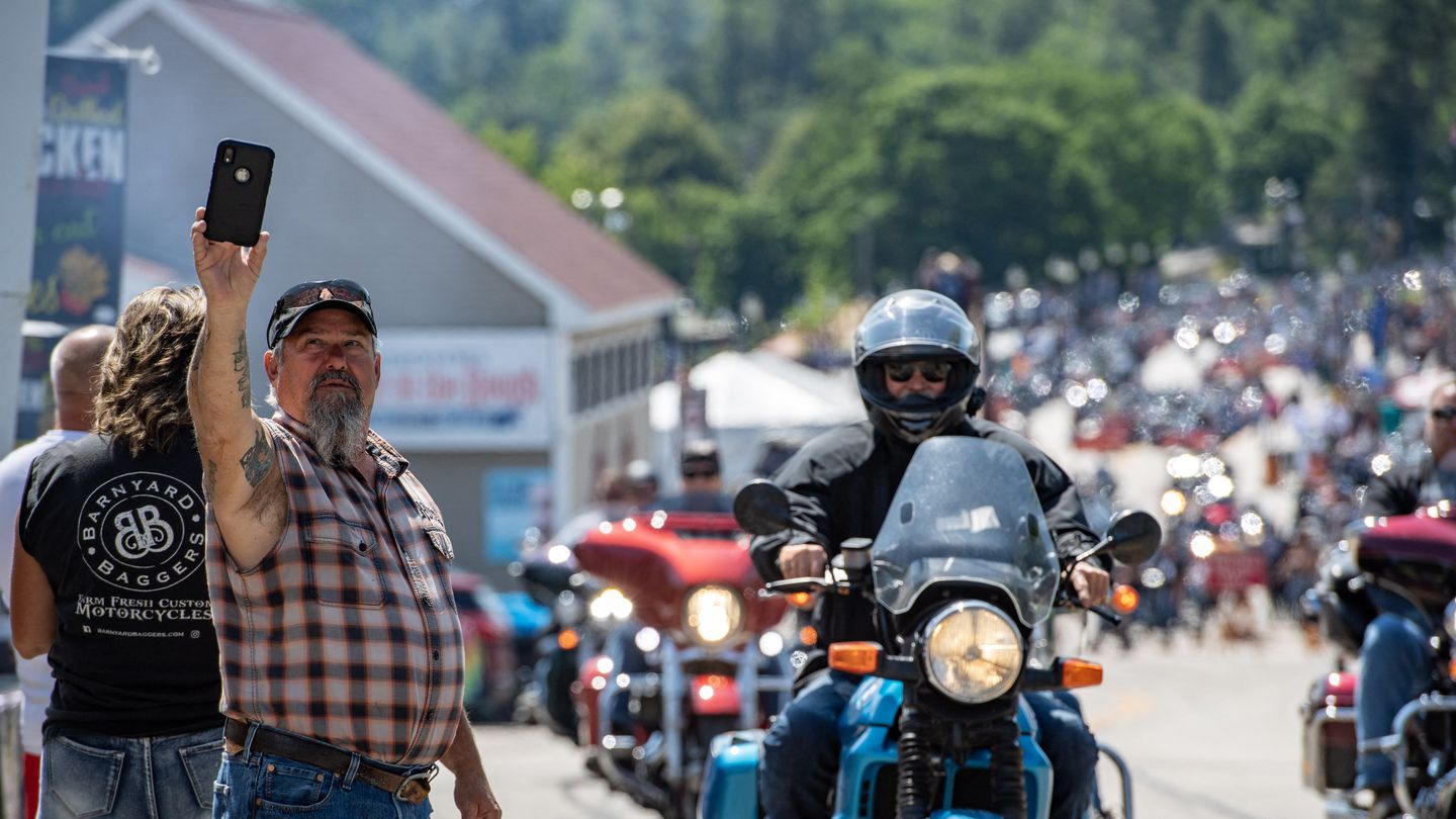 A person takes a photo with a convoy of motorcycles during the 100th anniversary of the Laconia Motorcycle Week in Laconia, New Hampshire, on June 11. The rally, which is expected to bring in over 300,000 motorcyclists, is considered to be the oldest in the US.