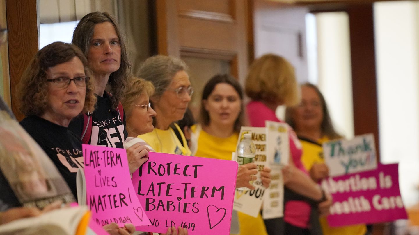 Protesters line the hallway leading to the House Chamber, June 21, at the State House in August, Maine.