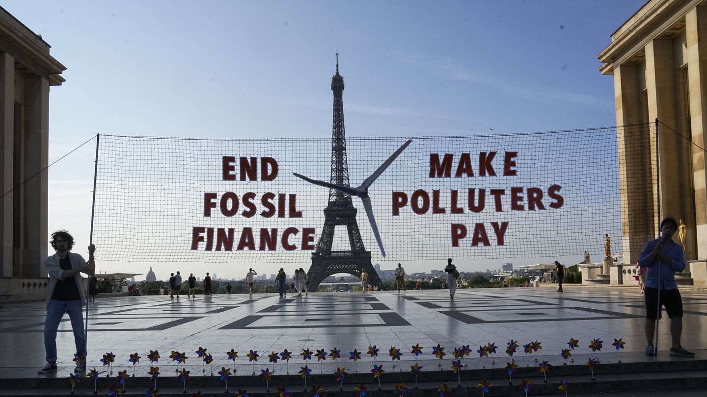 Climate activists participate in a demonstration ahead of the Global Climate Finance Summit, June 21, in Paris.